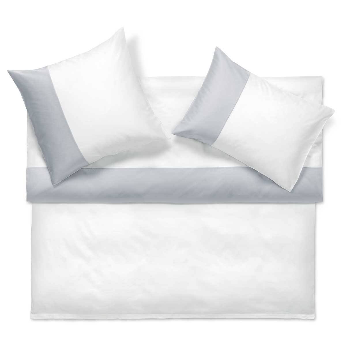 Ein Bett mit weisser Bettwäsche und zwei passenden weissen Kissen mit grauen Akzenten. Die Bettwäsche ist ordentlich auf einem weissen Hintergrund arrangiert.