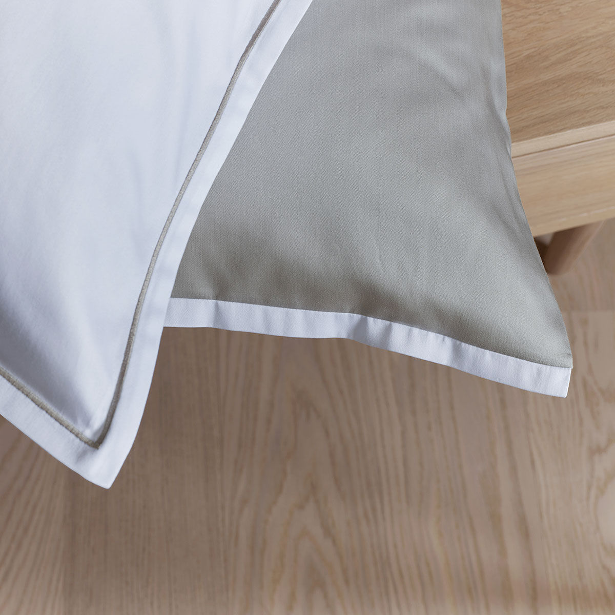 Eine Nahaufnahme der Bettwäsche Clark, die den weissen Bezug mit hellem Rand und die hochwertige Verarbeitung zeigt.