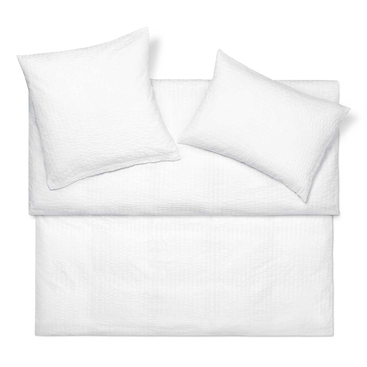 Bettwäsche Dean in Weiss Set aus weisser Bettwäsche Dean mit gestepptem Design, bestehend aus einem Kissenbezug und einem Bettbezug, auf einem weissen Hintergrund arrangiert.