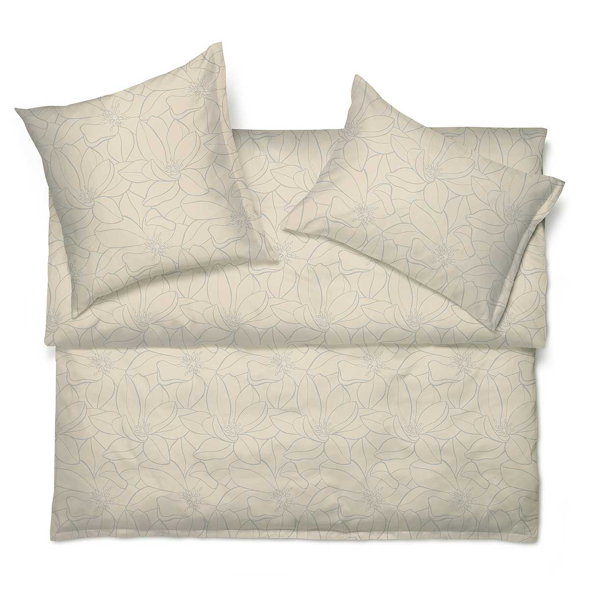 Bettwäsche Set Magnolia in Beige, floral gemustert, arrangiert auf einem Bett.