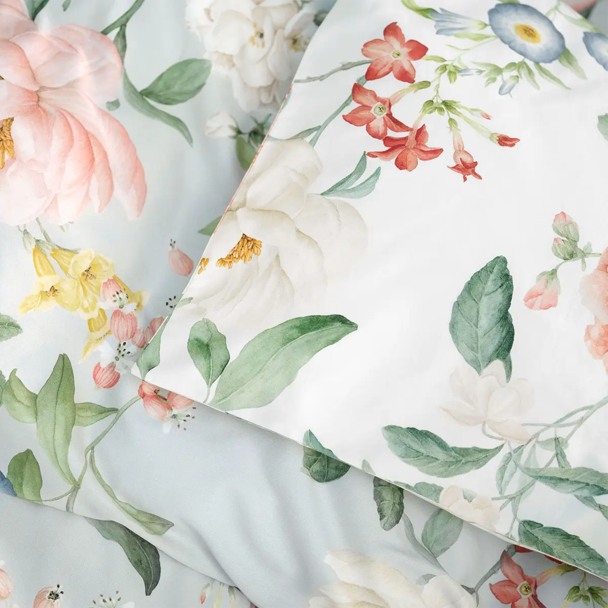 Detailansicht der Bettwäsche Artemis, die bunte Blüten und Blätter zeigt.