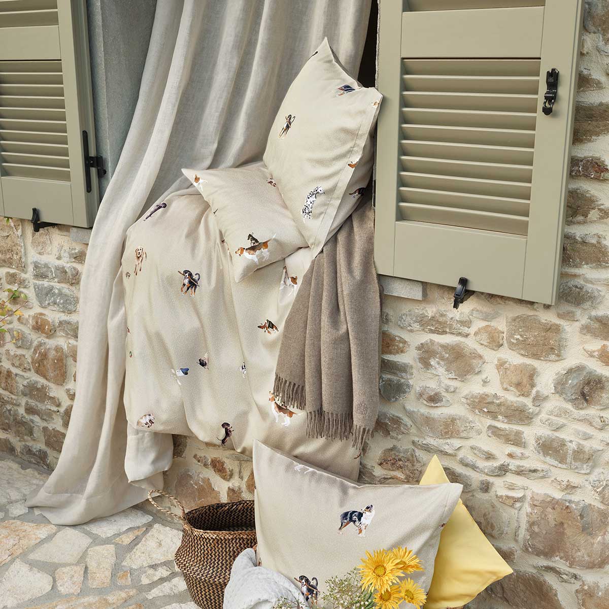 Bello Bettwäsche Outdoor-Szene Bello Bettwäsche in einem Outdoor-Szenario, drapiert über einem Fensterbrett, umgeben von Vorhängen, Decken und Kissen.