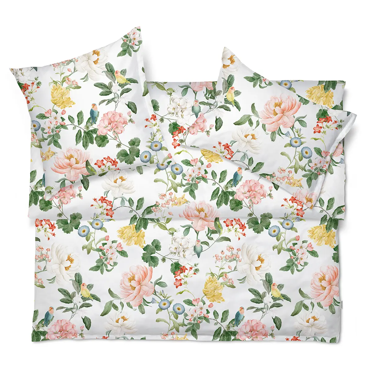 Bettwäsche Artemis mit einem floralen Muster, arrangiert auf einem Bett.