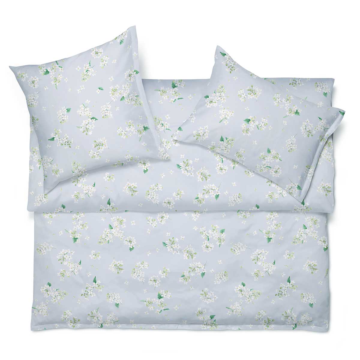 Die Bettwäsche May in Blau mit einem zarten Blumenmuster, perfekt arrangiert auf einem Bett für ein frisches und einladendes Ambiente.