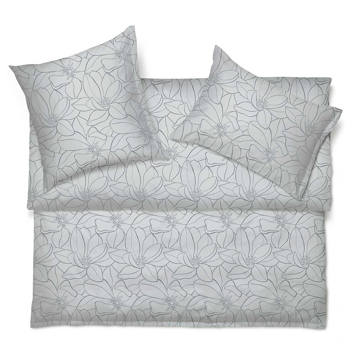 Magnolia Bettwäsche Set in Grau auf einem Bett Bettwäsche Set Magnolia in Grau mit floralem Muster, elegant auf einem Bett arrangiert.