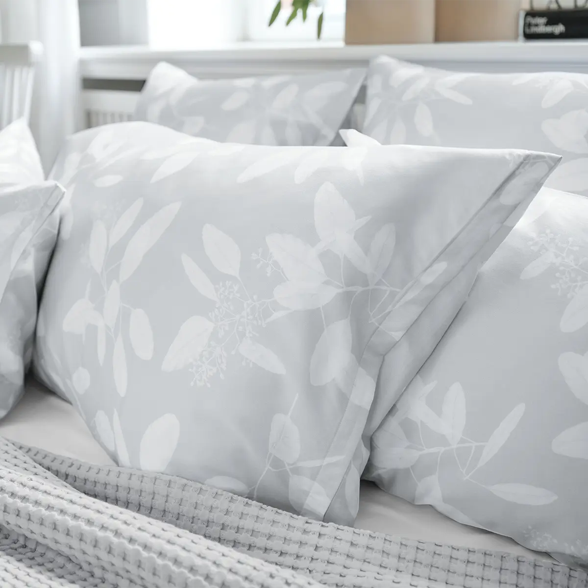 Nahaufnahme der Omeo Bettwäsche in Beige mit dezentem Blattmuster auf einem Kissenbezug.