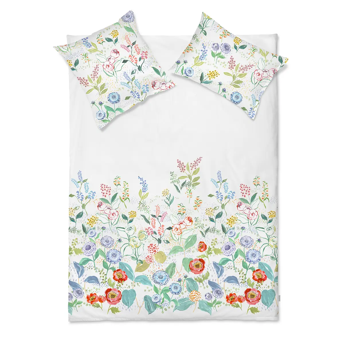 Ein Bett mit weisser Bettwäsche und floralem Muster. Die Bettwäsche zeigt bunte Blumen und Blätter in verschiedenen Farben.