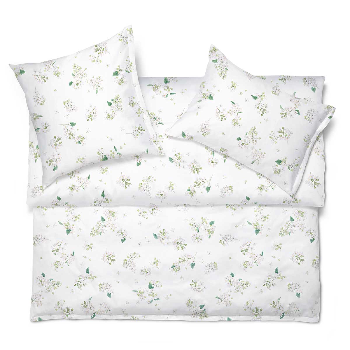 Bettwäsche May in Weiss mit Blumenmuster Die Bettwäsche May mit zarten weissen Blüten und grünen Blättern auf weissem Hintergrund, perfekt arrangiert auf einem Bett.