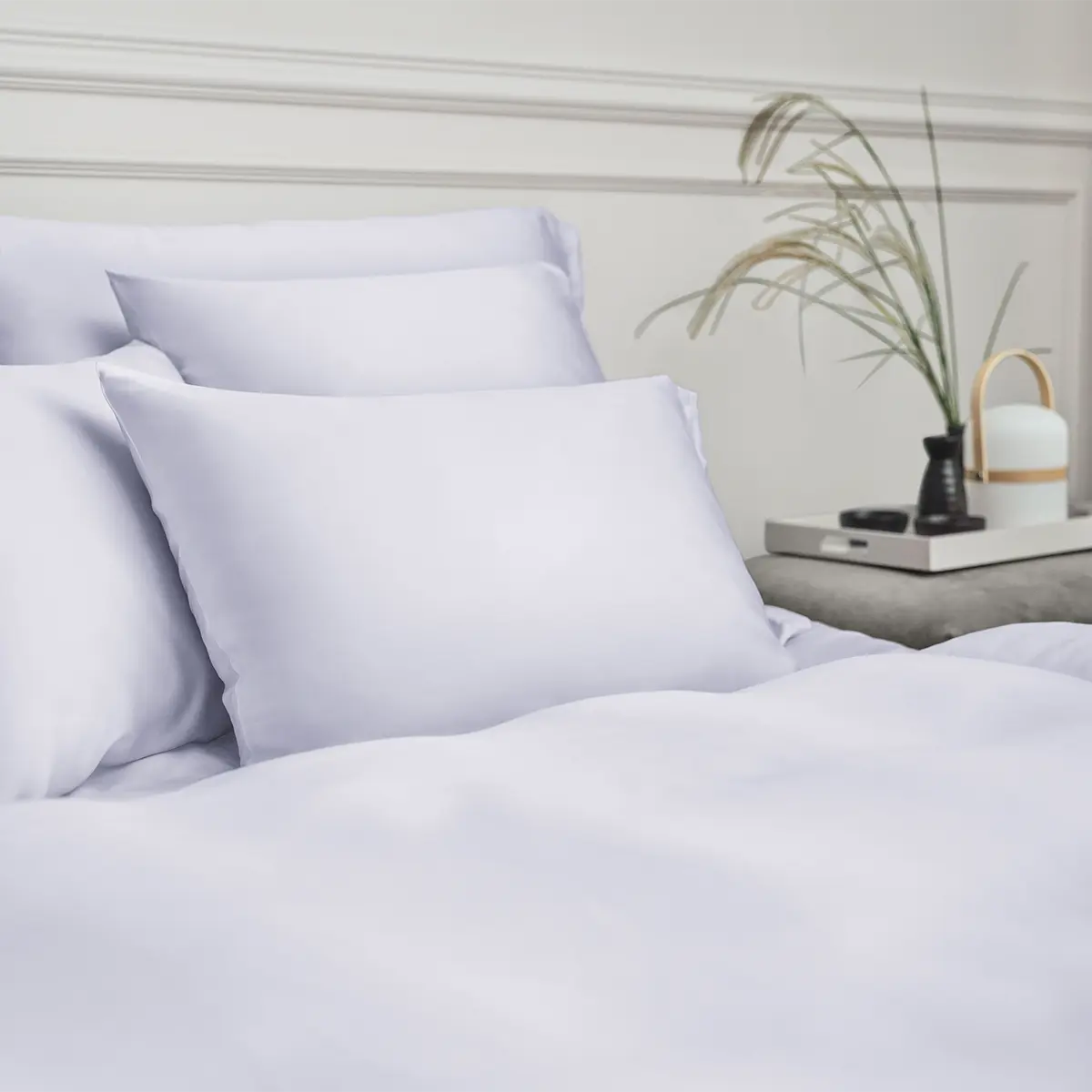 Nahaufnahme der Micromodal Bettwäsche in der Farbe Glace, die elegant auf einem Bett arrangiert ist, mit dezenten Details im Hintergrund.